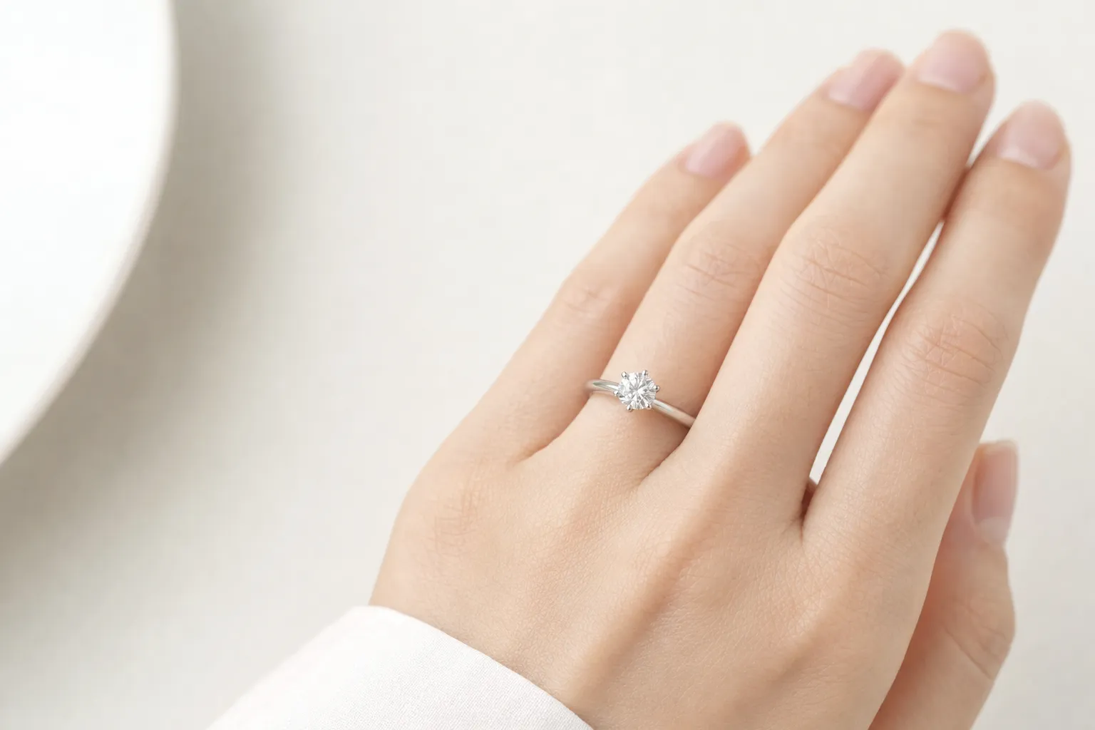 Classic prong setting with a round brilliant diamond in white gold on a hand
