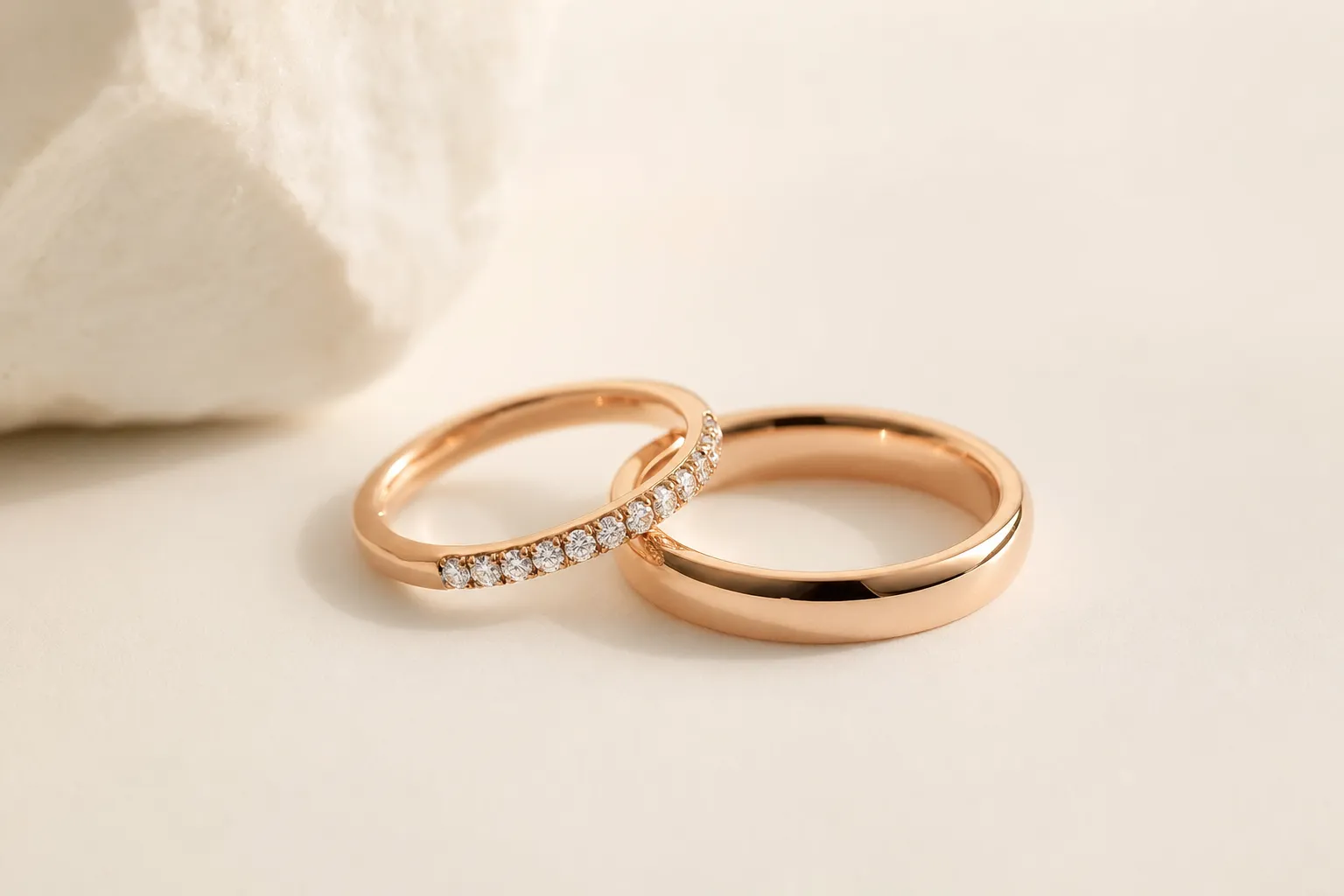 Wedding band half set with channel-set diamonds next to a plain band, rose gold