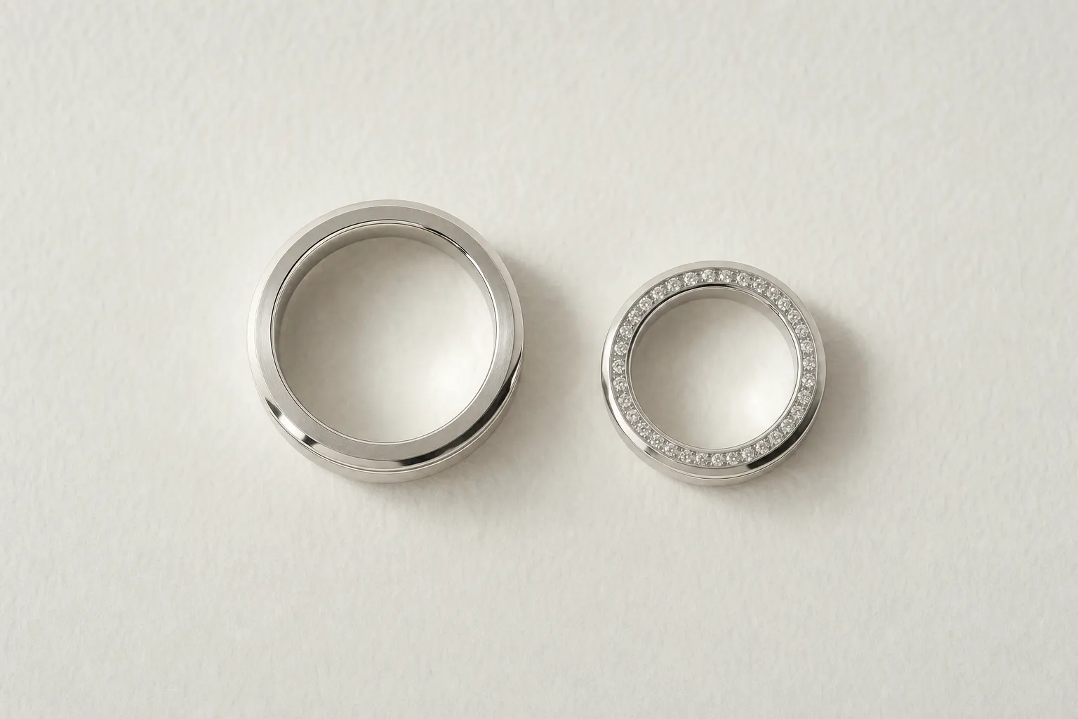 Ein Paar Eheringe aus Platin, ein breiterer und ein schmalerer Ring, nebeneinander