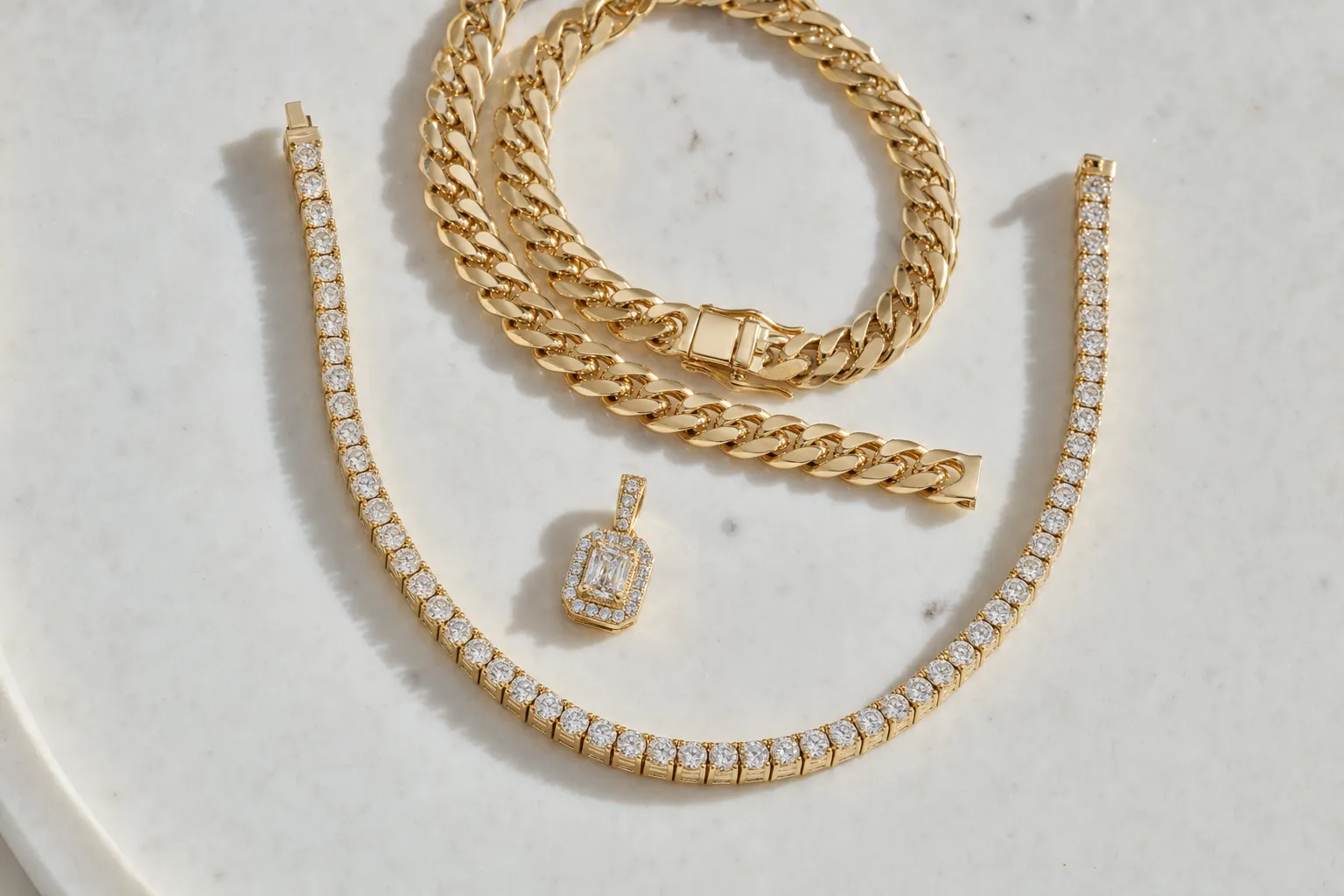 Diamant-Tennis-Chain, Cuban-Link-Kette und kleiner Iced-Out-Anhänger auf warmem weissem Marmor