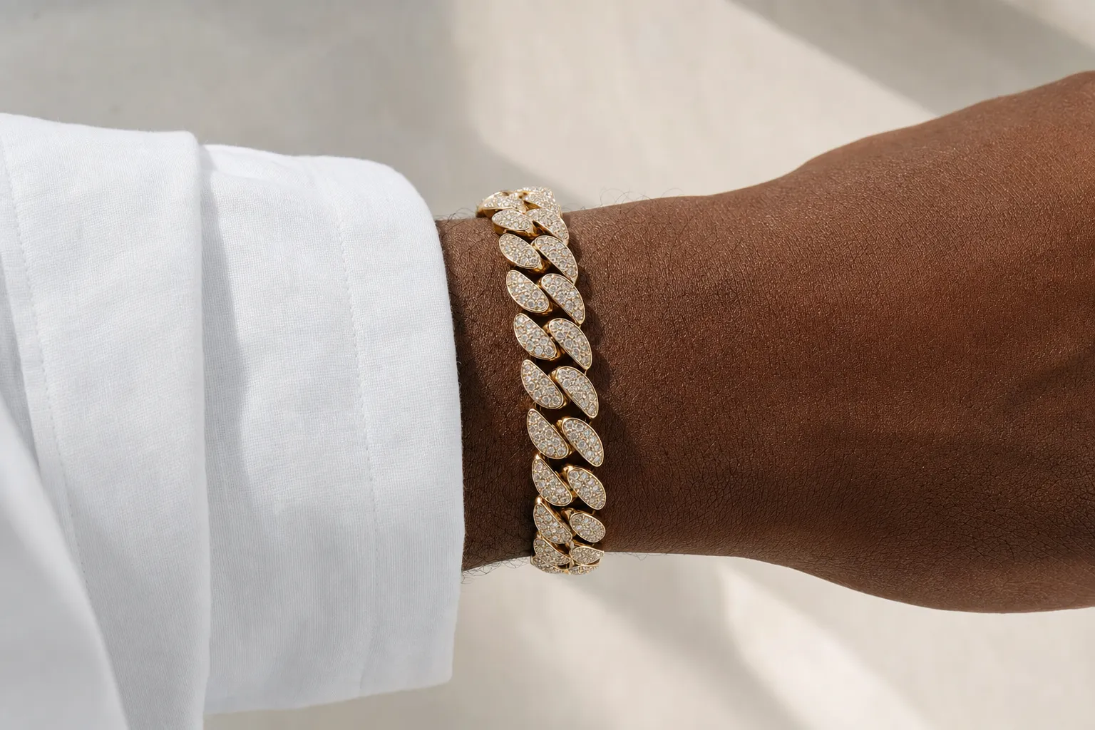 Iced-Out-Cuban-Link-Armband mit Pavé-Diamanten in Gelbgold am Handgelenk eines Mannes