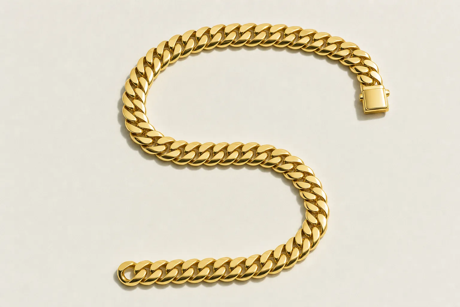 Zinxhir masiv Miami Cuban link 10 mm në ar të verdhë të lustruar, i vendosur në formë S mbi letër të ngrohtë
