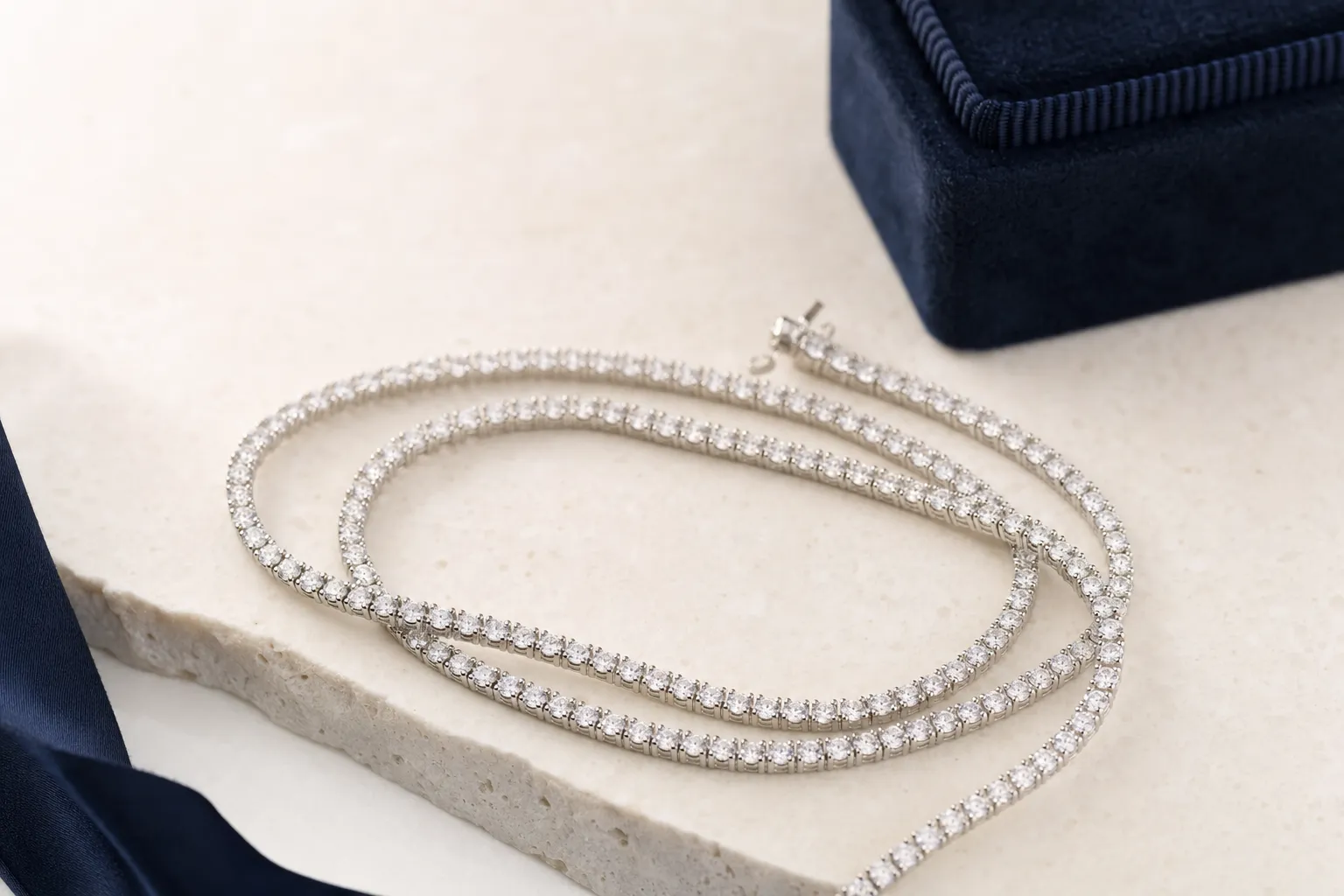 Tennis chain with 4 mm lab-grown diamonds in white gold on a light stone surface