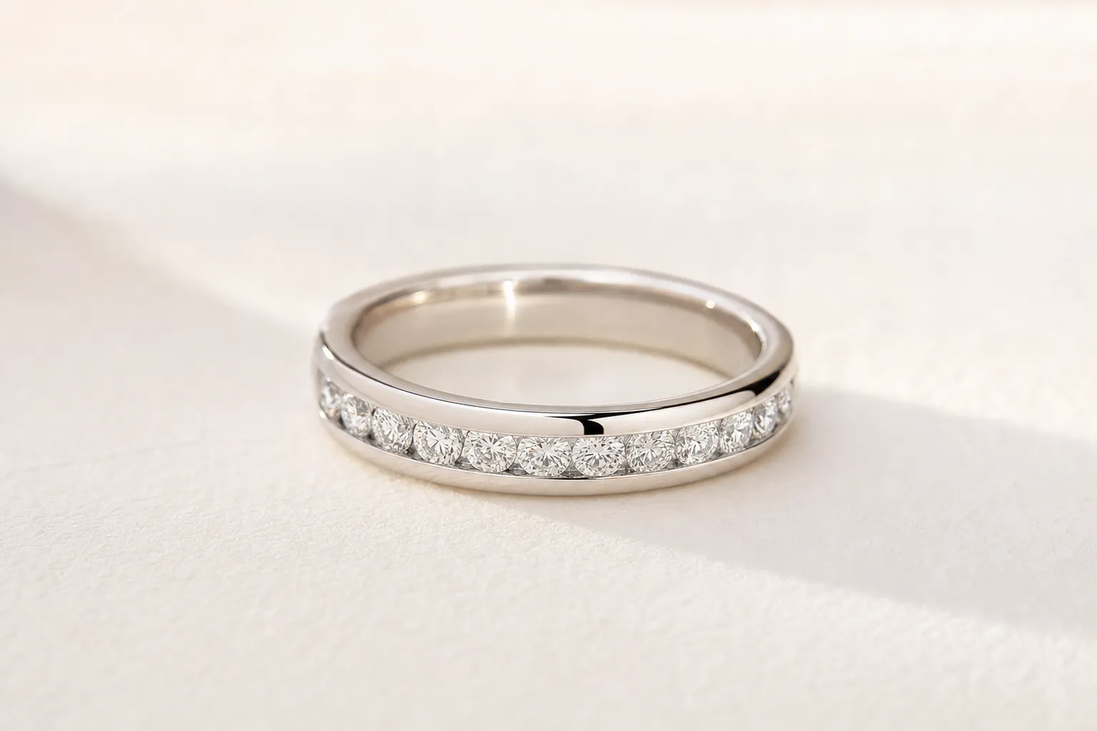 Channel setting with round diamonds between two smooth metal rails in white gold