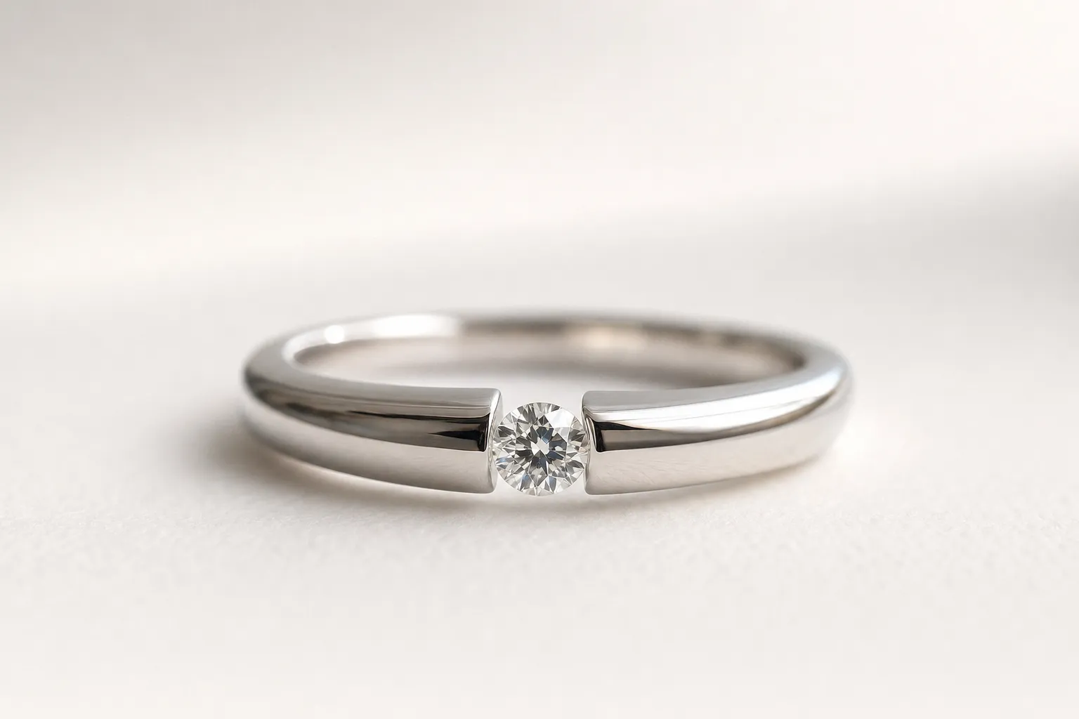 Platinum tension setting where the diamond appears to float freely between the two ends of the band