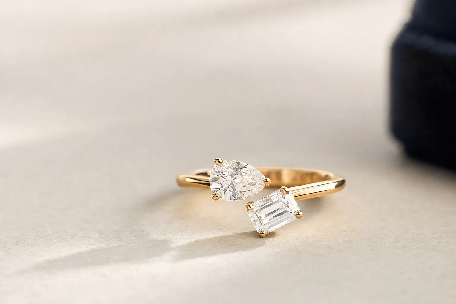 Toi et Moi Verlobungsring mit einem Tropfen- und einem Smaragdschliff-Diamant, die auf einer offenen Schiene aufeinandertreffen, Gelbgold