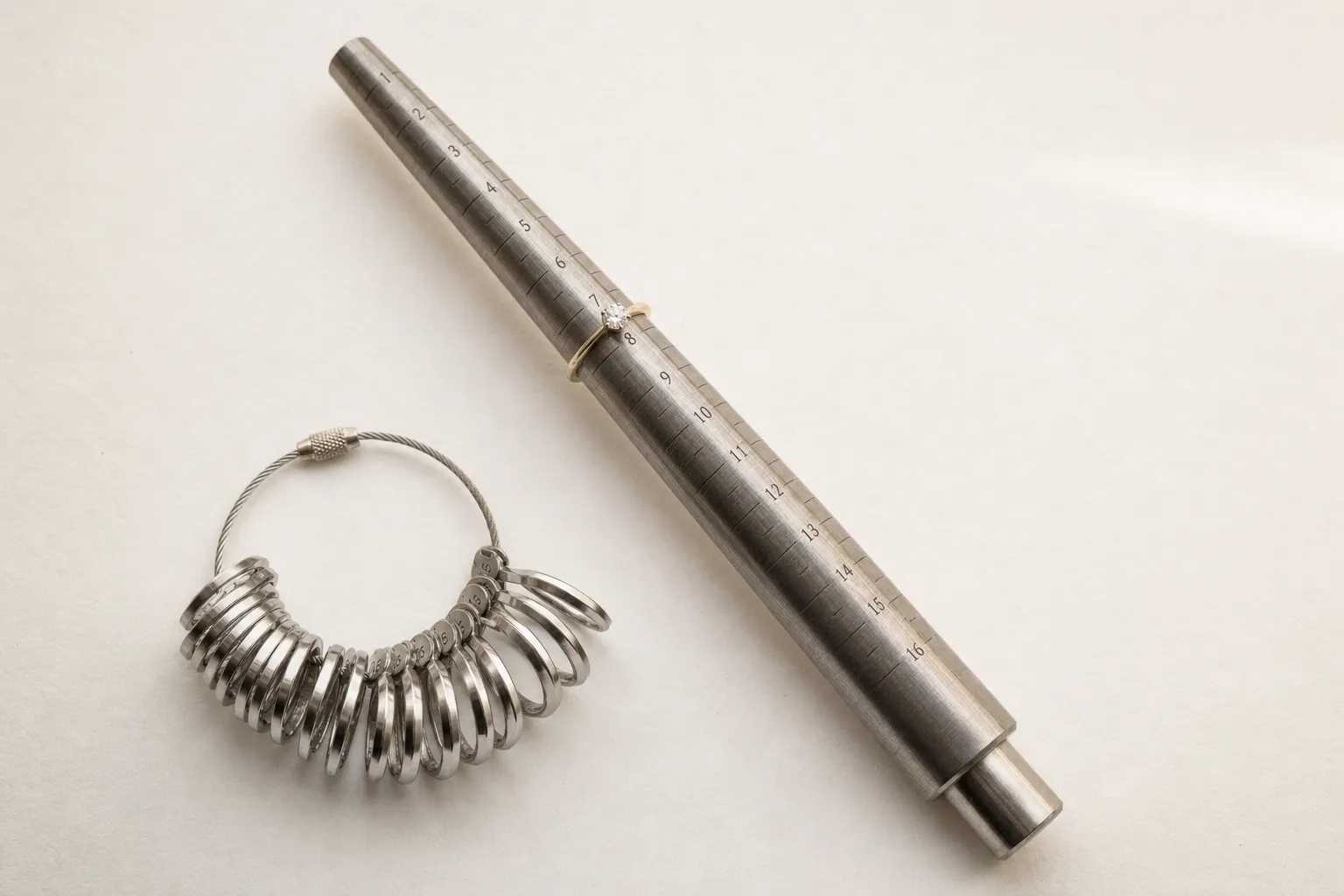 Ein Ringmass mit eingravierten Grössen und ein Ringstab liegen auf hellem Papier, bereit für die Ringgrössen-Messung